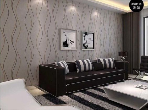 sala decorada com papel de parede e sofá preto