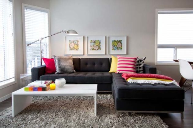 sala decorada sofá preto com almofadas