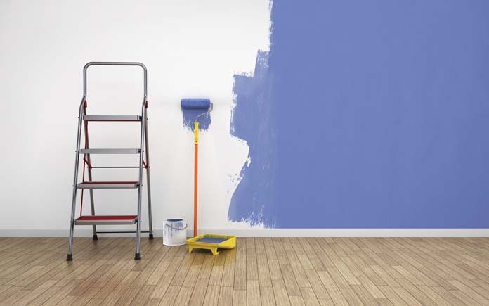 parede meio pintada de azul, com rolo e escada