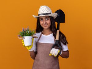 Mulher segurando ferramentas para jardinagem.