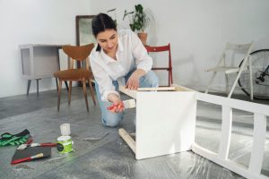Mulher praticando a bricolagem ao reformar móveis.