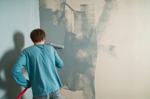 Homem ao pintar parede usando equipamentos certos. 