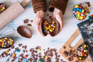 Pessoa segurando ovos de chocolate ao descobrir como economizar na Páscoa. 