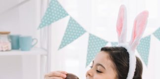 Menina comendo ovos de chocolate ao saber como economizar na Páscoa.
