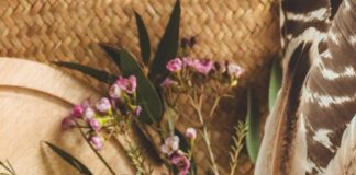 happy-easter-background-pink-easter-eggs-nest-with-floral-decorations-feathers-near-window