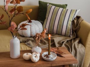 sala de estar com a decoração de outono com almofadas e velas.