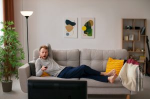 Homem relaxando em sofá ao entender se vale a pena morar em flat.