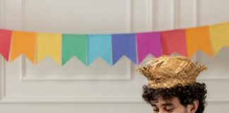 rapaz fazendo a decoração de festa junina em casa.