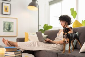 Mulher em sala com cachorro como exemplo de pessoa com animais em apartamentos.