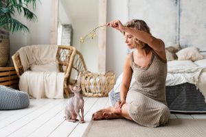 Mulher brincando com gato. Exemplo de animais em apartamentos. 