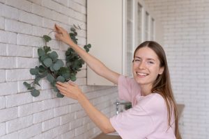 Mulher no processo de Renovar a casa para o ano novo colocando decoração na parede.