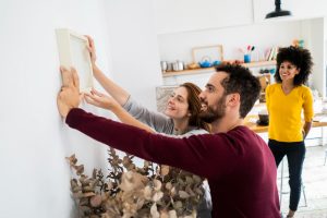 casal fazendo o processo de Renovar a casa para o ano novo com decoração de parede.