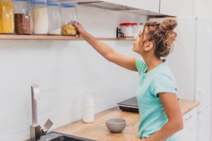 mulher descobrindo como organizar armário de cozinha.