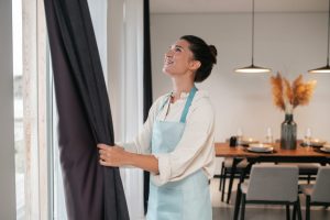 mulher satisfeita e sabe como escolher cortinas para ambientes internos