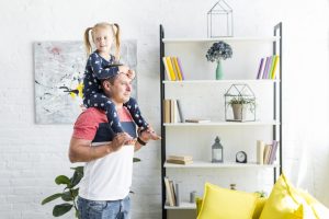 Homem carregando filha após seguir as dicas para decoração de quartos infantis